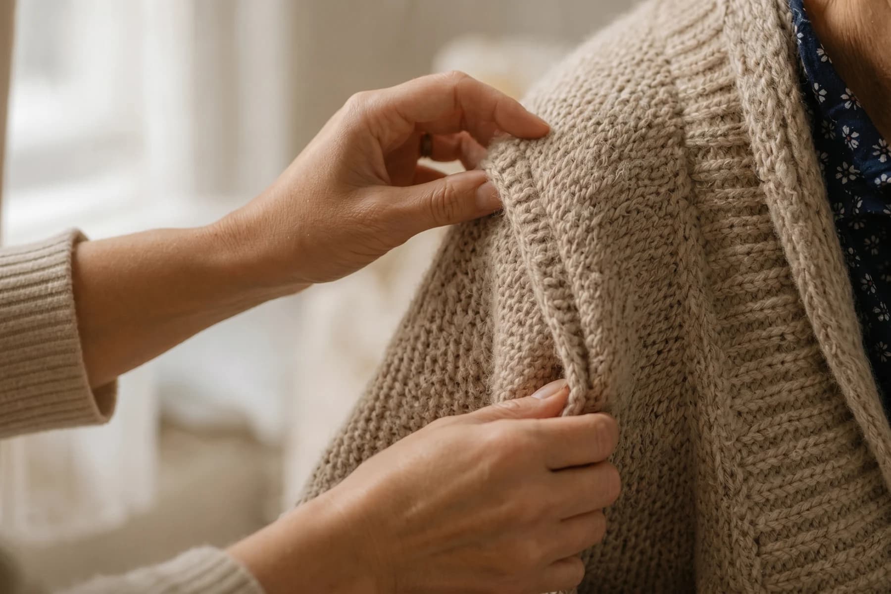 Gentle hands helping with a cardigan — personal care at home